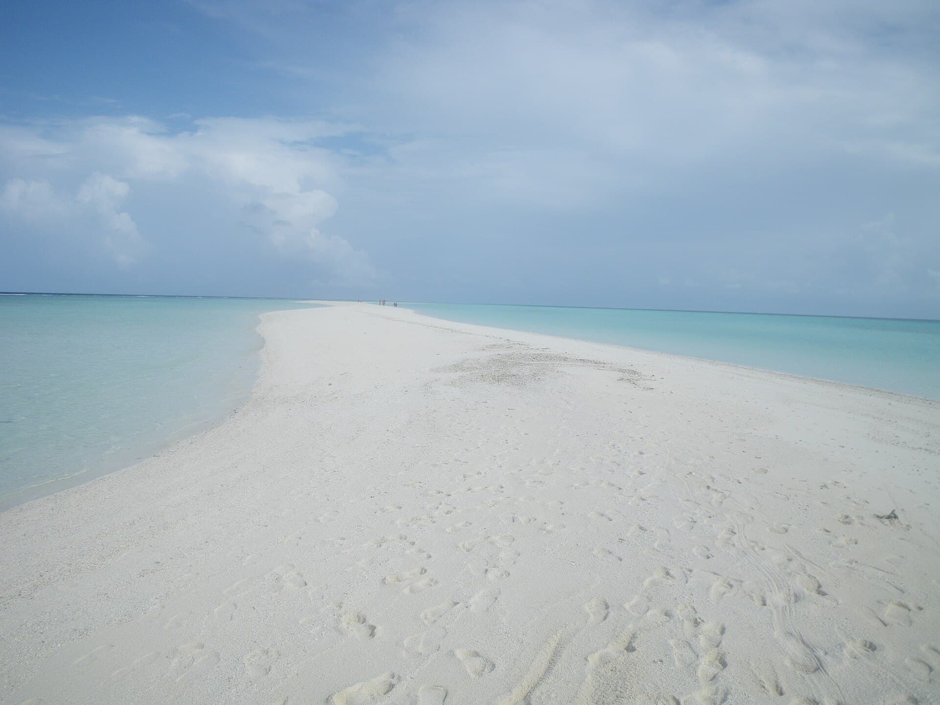 A tiny white sandbank in a turquoise Maldives lagoon